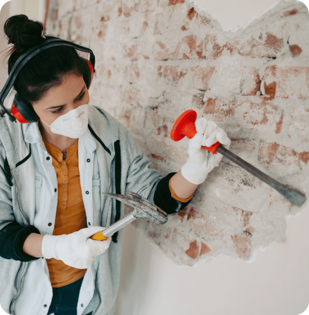 Person using a paint roller to paint a wall red.